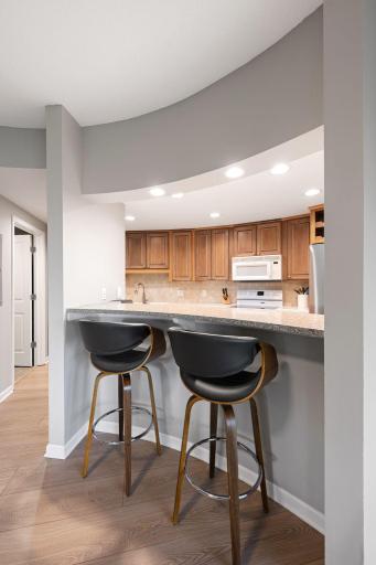 Inviting kitchen peninsula with bar seating, granite-style countertop, recessed lighting, and an open feel ideal for casual dining.