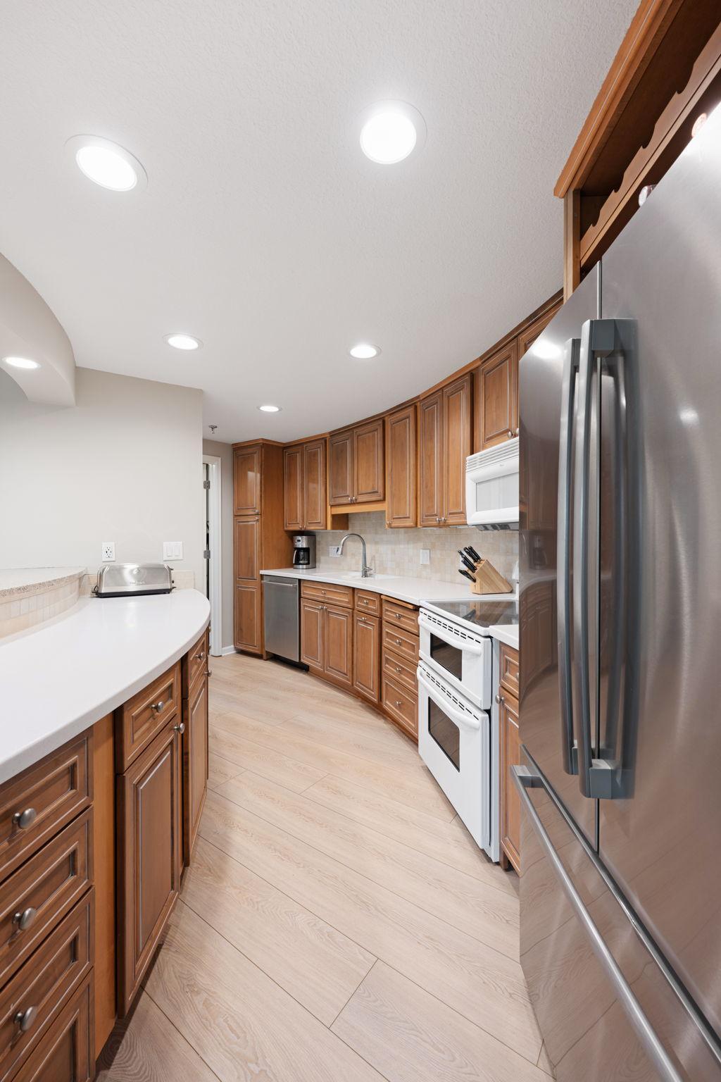 Kitchen featuring ample cabinetry, stainless steel appliances, generous counter space, recessed lighting, and convenient breakfast bar.