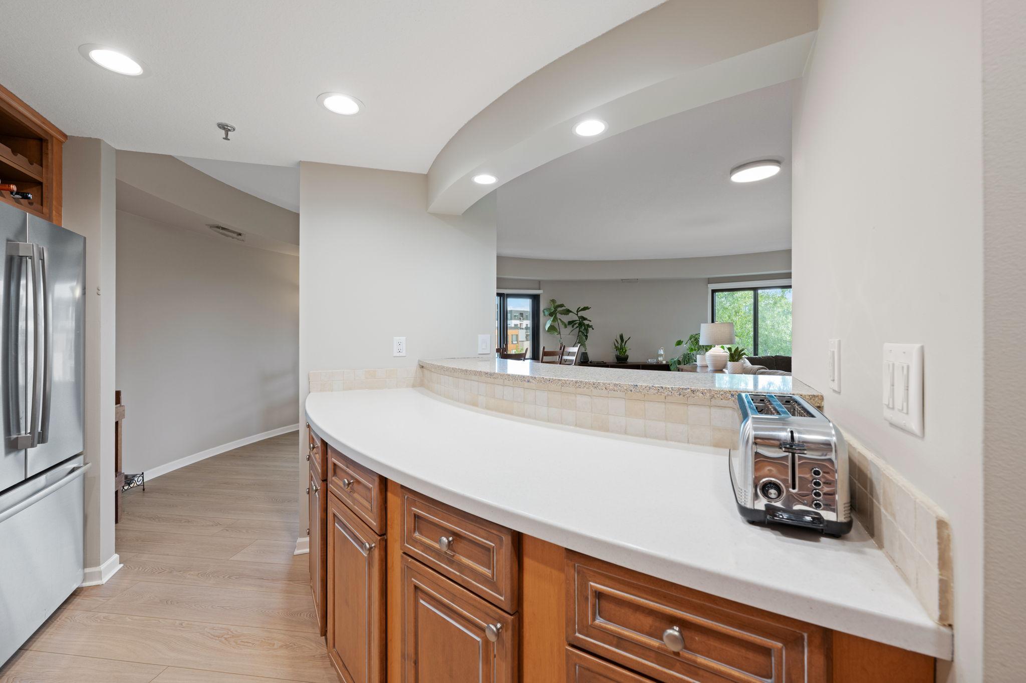 Generous kitchen pass-through with extended counter space, bar seating potential, and an open connection to the living and dining areas.