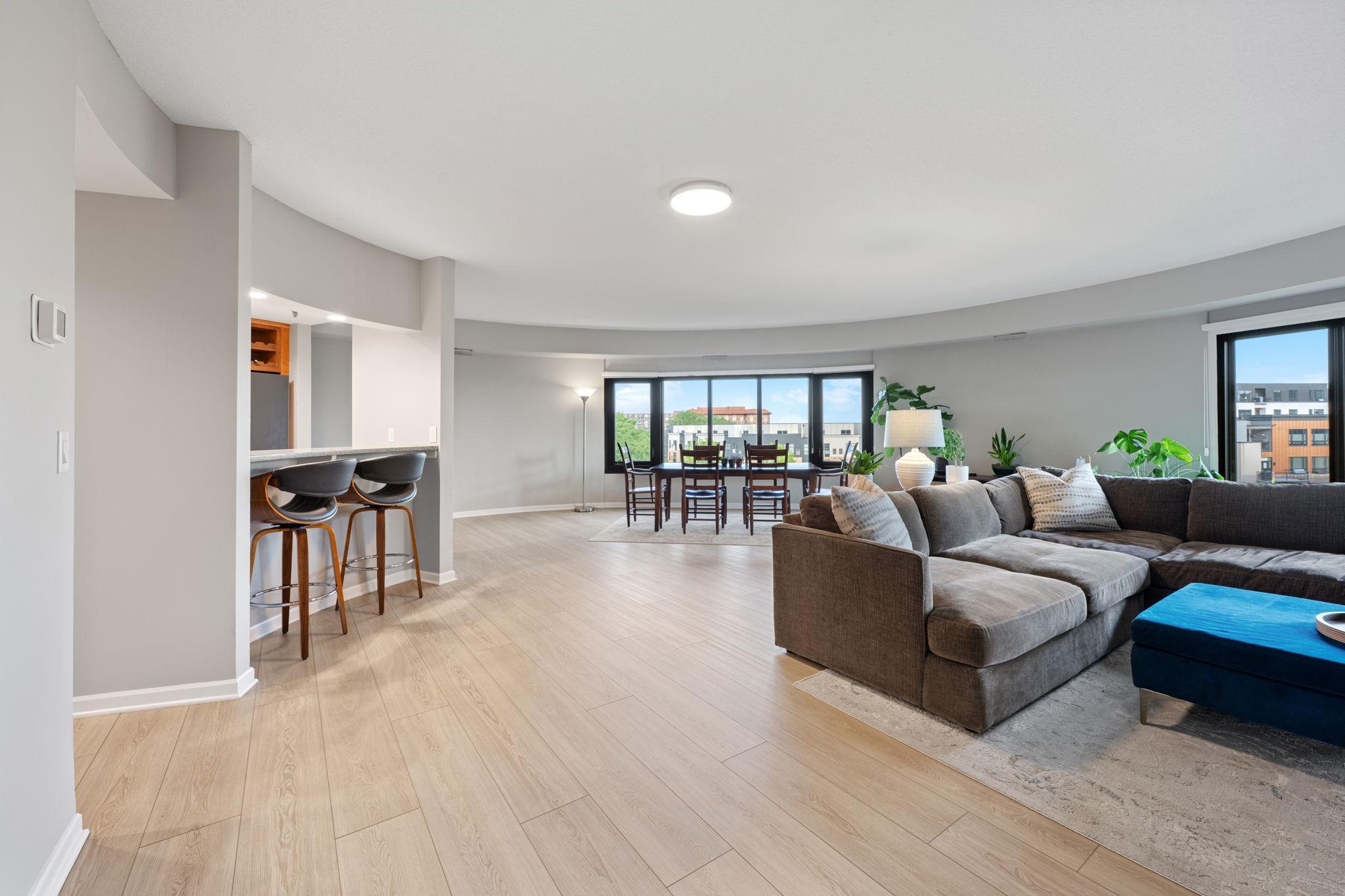 Bright open-concept living and dining area featuring generous space for entertaining, large windows, and seamless flow into the kitchen.