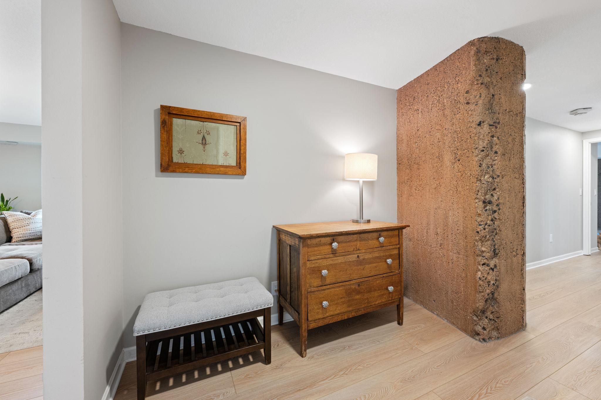 Charming foyer area featuring a unique architectural accent wall, neutral finishes, and flexible space for décor or storage.