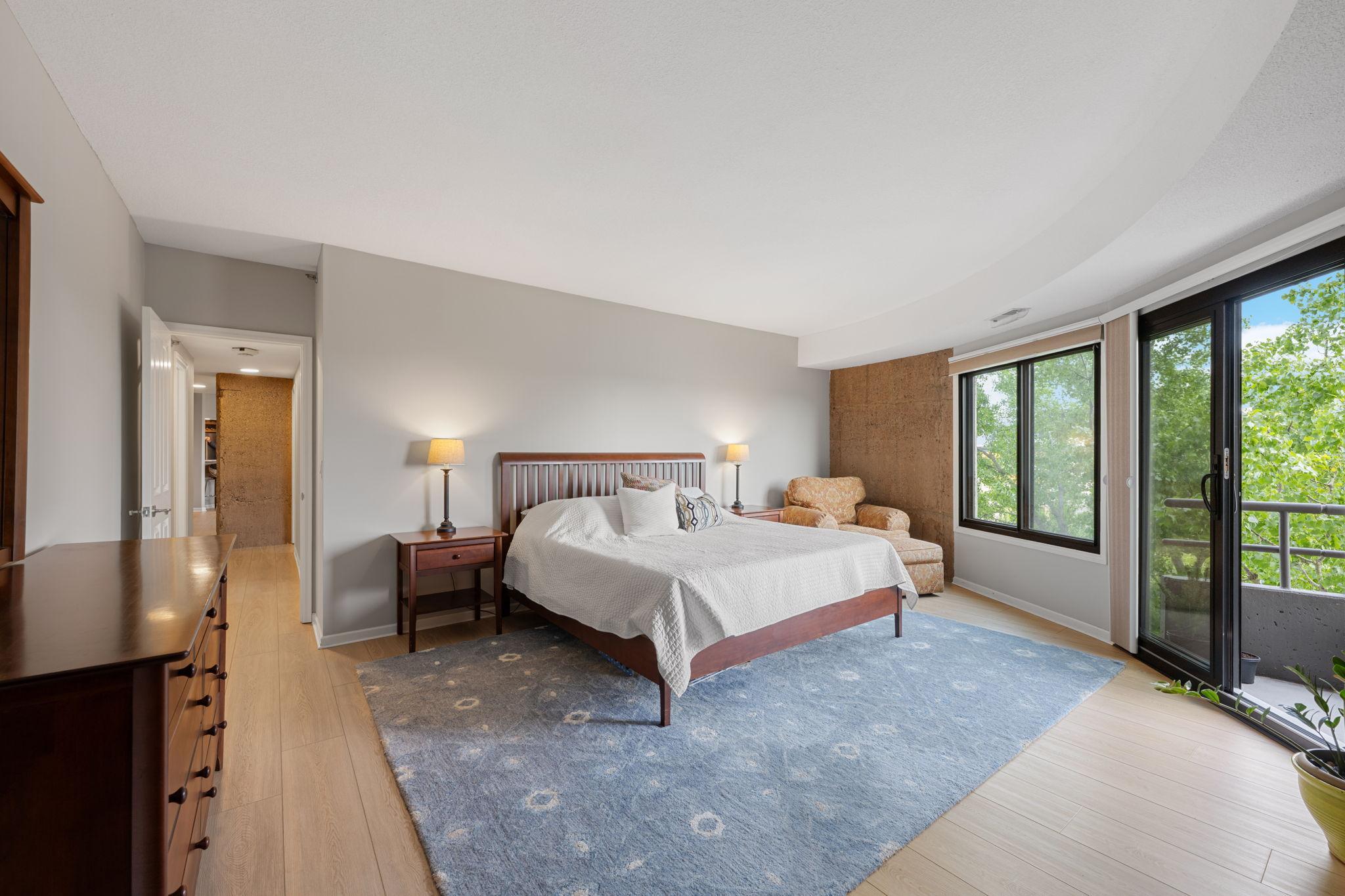 Private primary suite with balcony directly accessible from the bedroom, creating a peaceful indoor-outdoor retreat with green views.