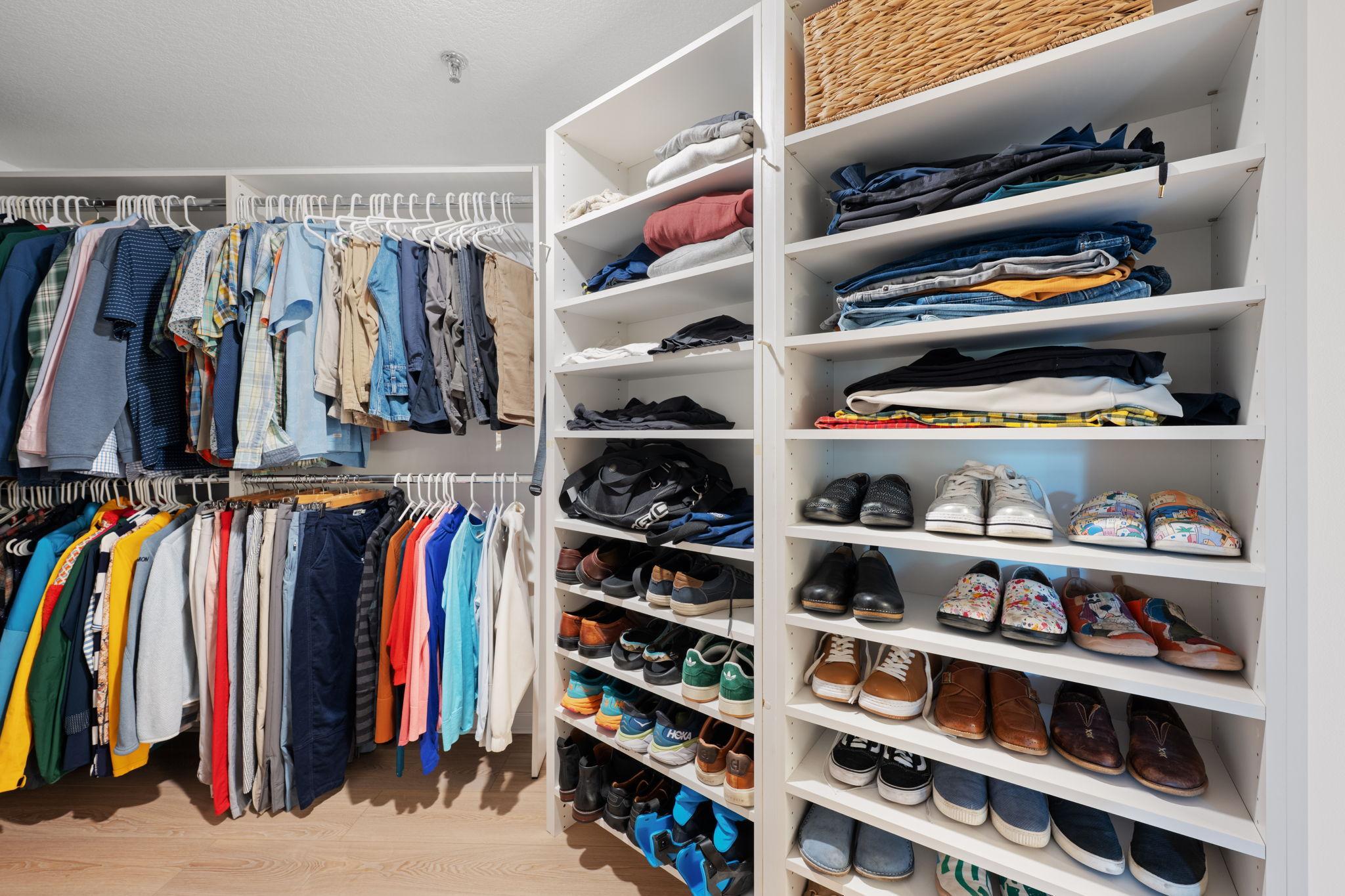 Spacious walk-in closet with multiple hanging areas, open shelving, and thoughtful storage for clothing and accessories.