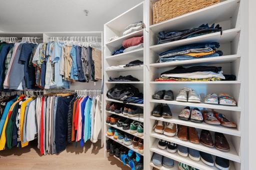 Spacious walk-in closet with multiple hanging areas, open shelving, and thoughtful storage for clothing and accessories.