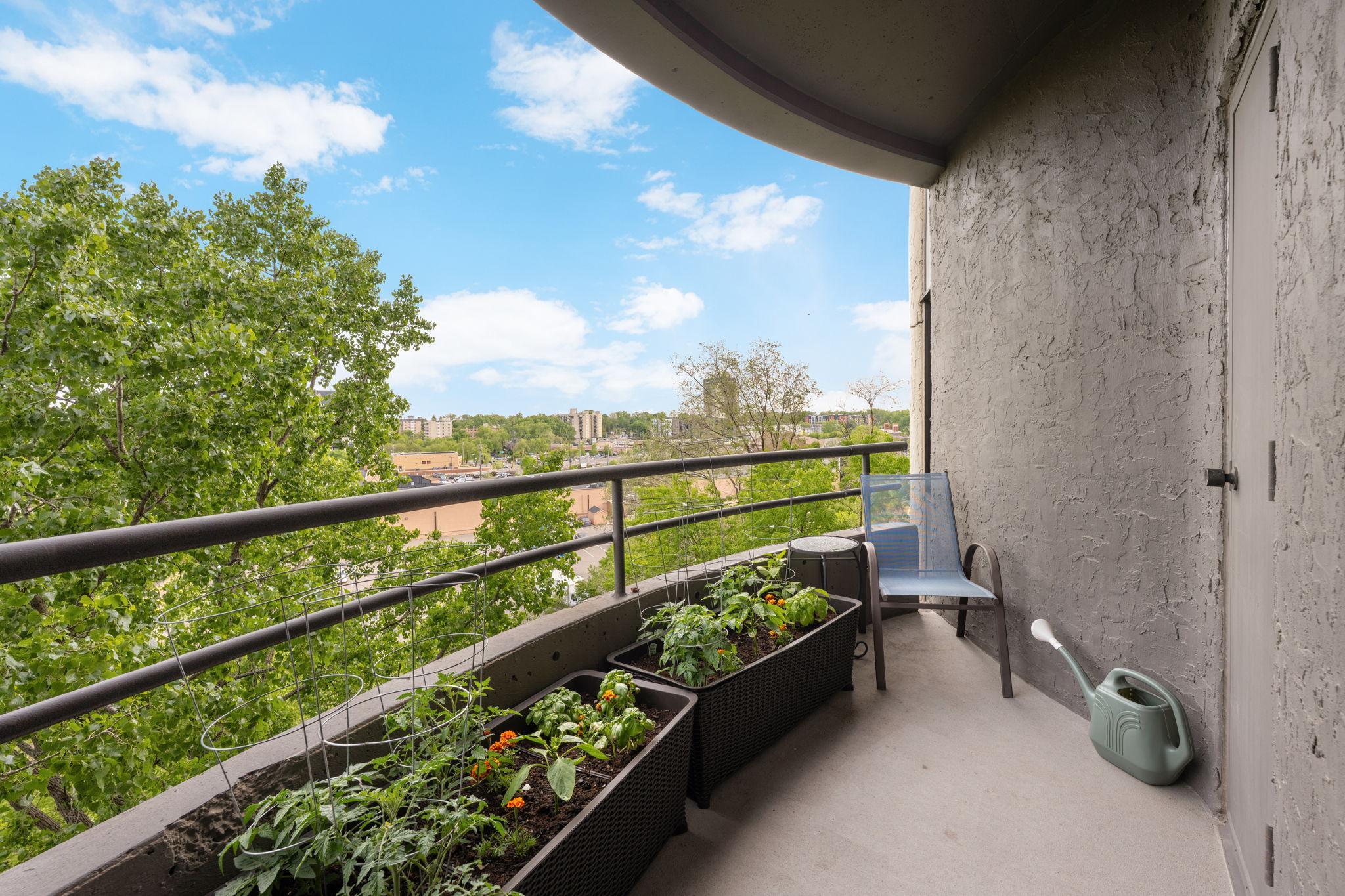Covered private balcony with room for seating and planters, offering peaceful treetop views and an inviting outdoor escape.
