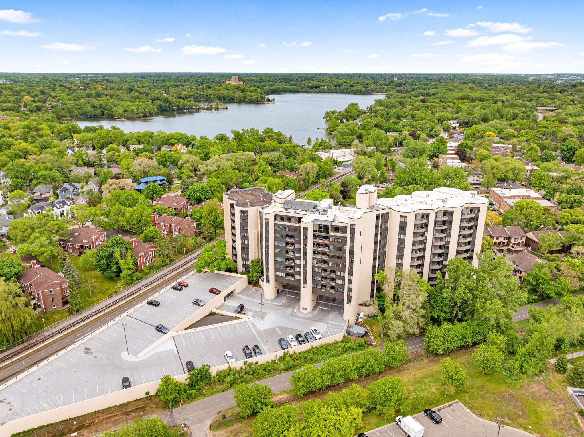 Wide aerial view highlighting the building’s incredible location near the lakes, parks, trails, and downtown Minneapolis skyline.