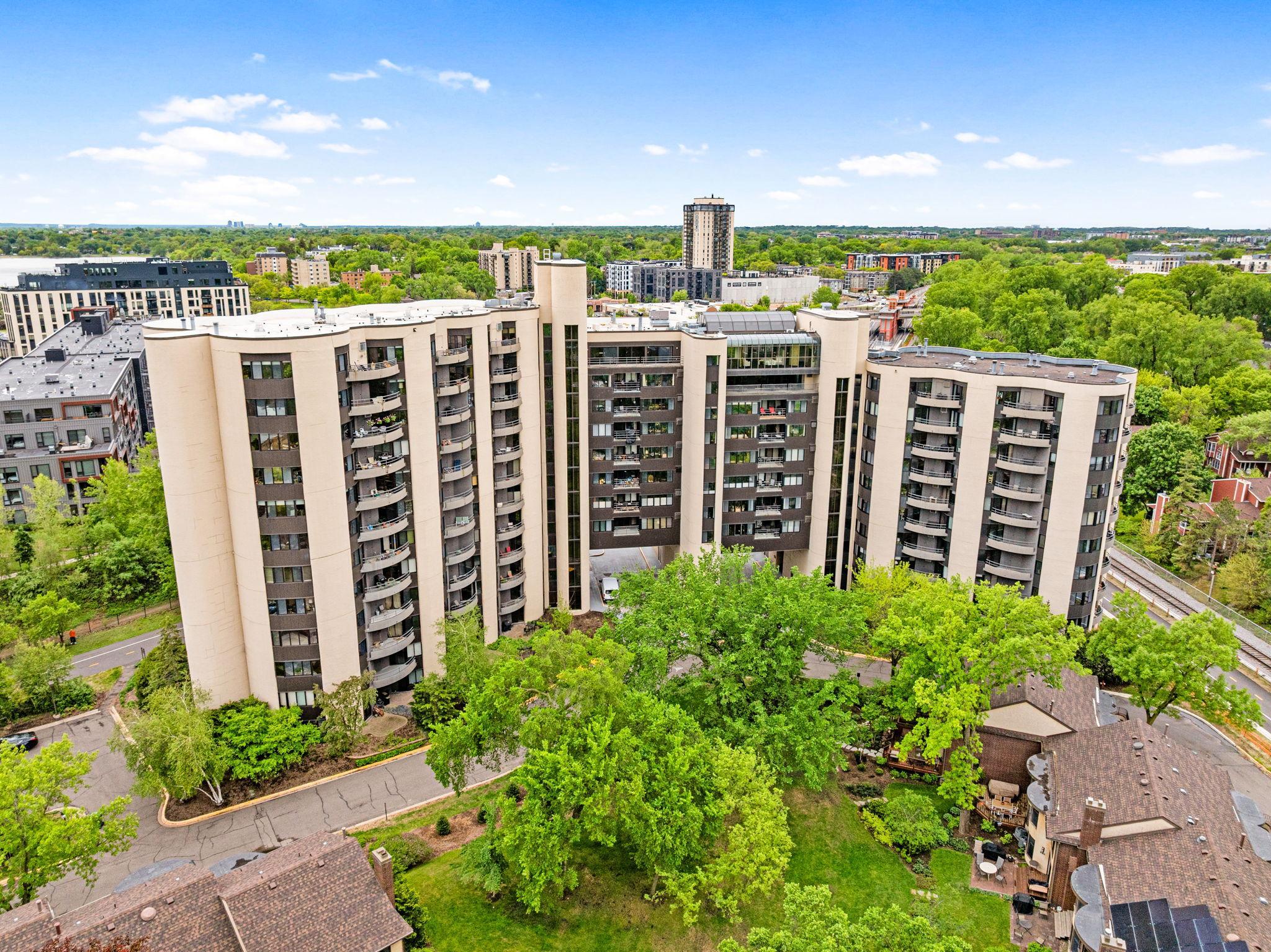 Aerial view of the Calhoun Isles community with downtown Minneapolis skyline views, nearby green space, and convenient surrounding amenities.
