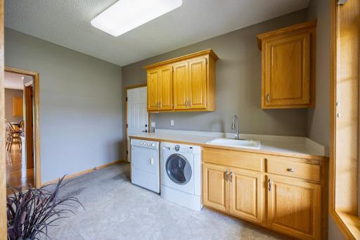 Large laundry room with storage, counterspace, and built-in laundry sink!