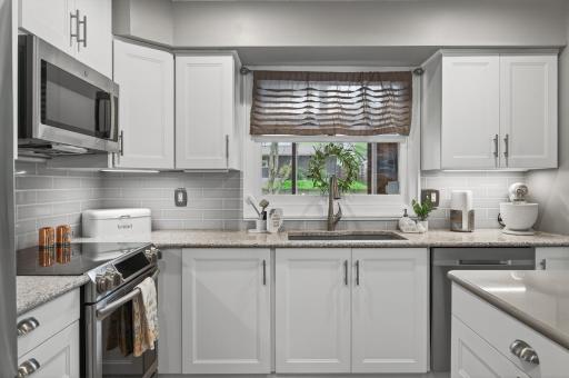 Subway tile backsplash, quartz countertops, undermount sink, and a window overlooking the backyard â thoughtfully updated in every direction you look.