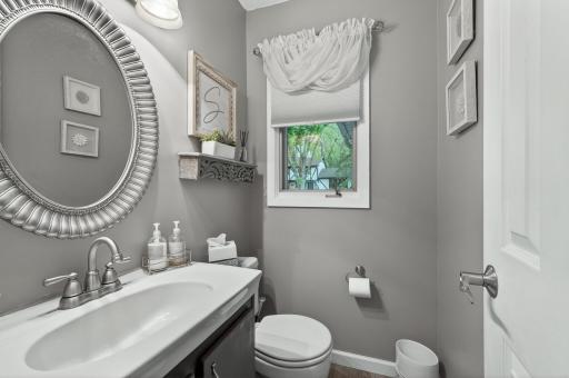 Stylish entry-level powder room with sunburst mirror, floating shelf, and updated vanity fixtures â beautifully styled and move-in ready.