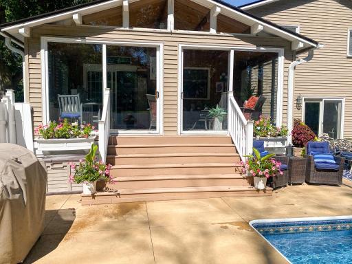 The backyard in full summer â blue water, green trees, and a lifestyle that's genuinely rare at this price point in Plymouth.
