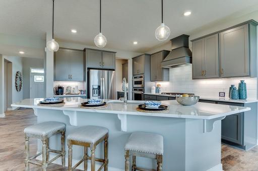 Welcome home! This popular Whitney floor plan offers a gourmet kitchen with gorgeous quartz counters, an exceptional island, and stainless appliances. Photos of model home, colors and finishes may vary.