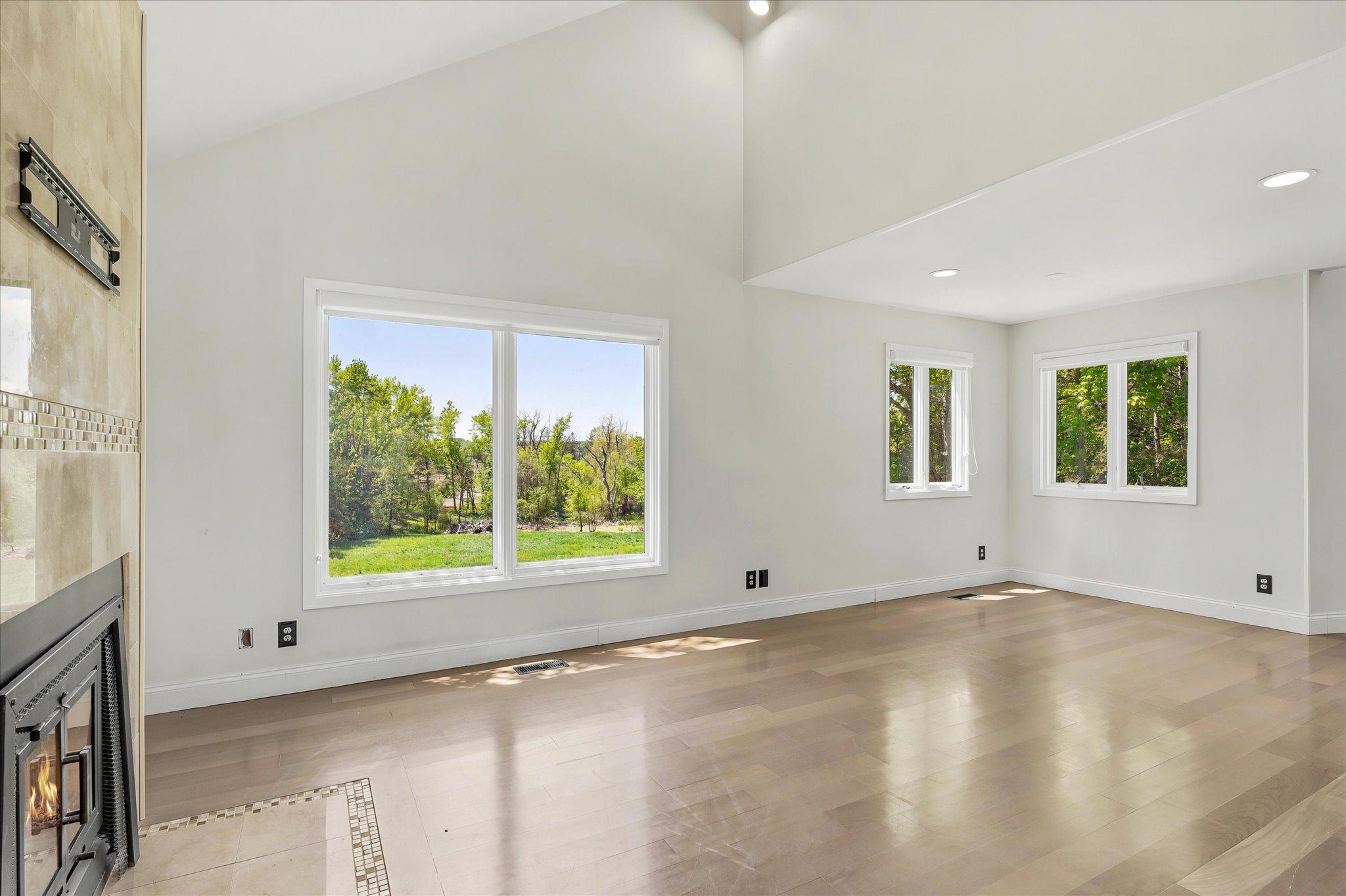 Main level family room with fireplace, vaulted ceilings and great views of property