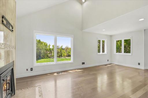 Main level family room with fireplace, vaulted ceilings and great views of property