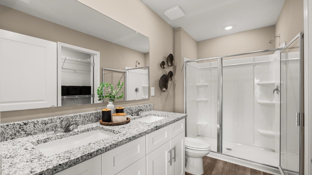 Primary bath. Actual home will include quite quartz countertops. All photos used are of a previous model home.