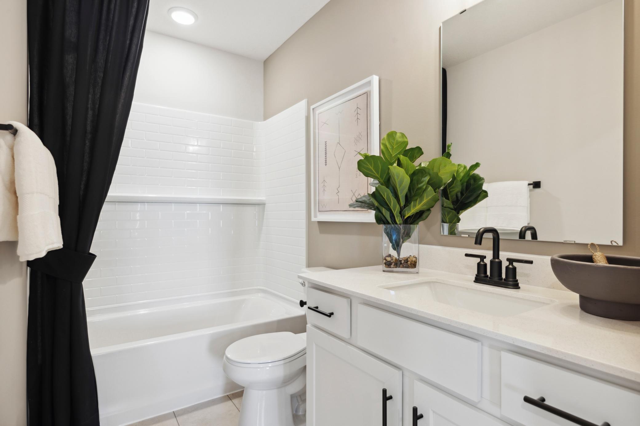 Upstairs Full Bathroom 2. Photo is of a similar Lowry model home.