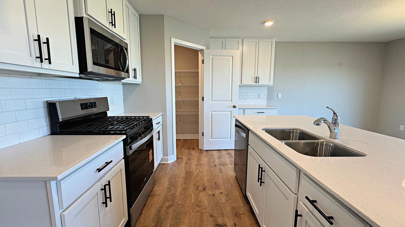 The Kitchen features quartz countertops, SS appliances, and subway tile backsplash. Photos represent another Dallas home previously for sale. Colors and options may vary.