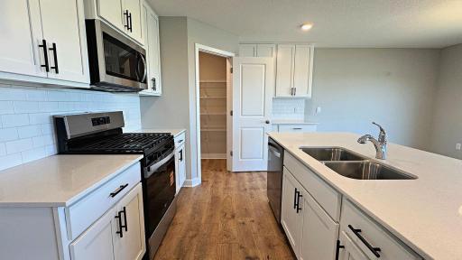 The Kitchen features quartz countertops, SS appliances, and subway tile backsplash. Photos represent another Dallas home previously for sale. Colors and options may vary.
