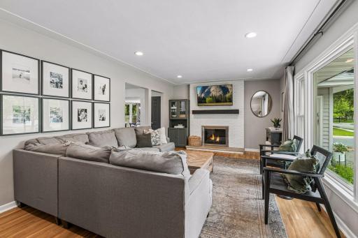 The main level features an inviting living room with wood-burning fireplace, eat-in kitchen, three bedrooms, and a full bathroom, with hardwood floors flowing throughout.