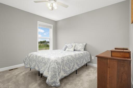 Bedroom #2 on the upper level has tall ceilings, ceiling fan and large window.