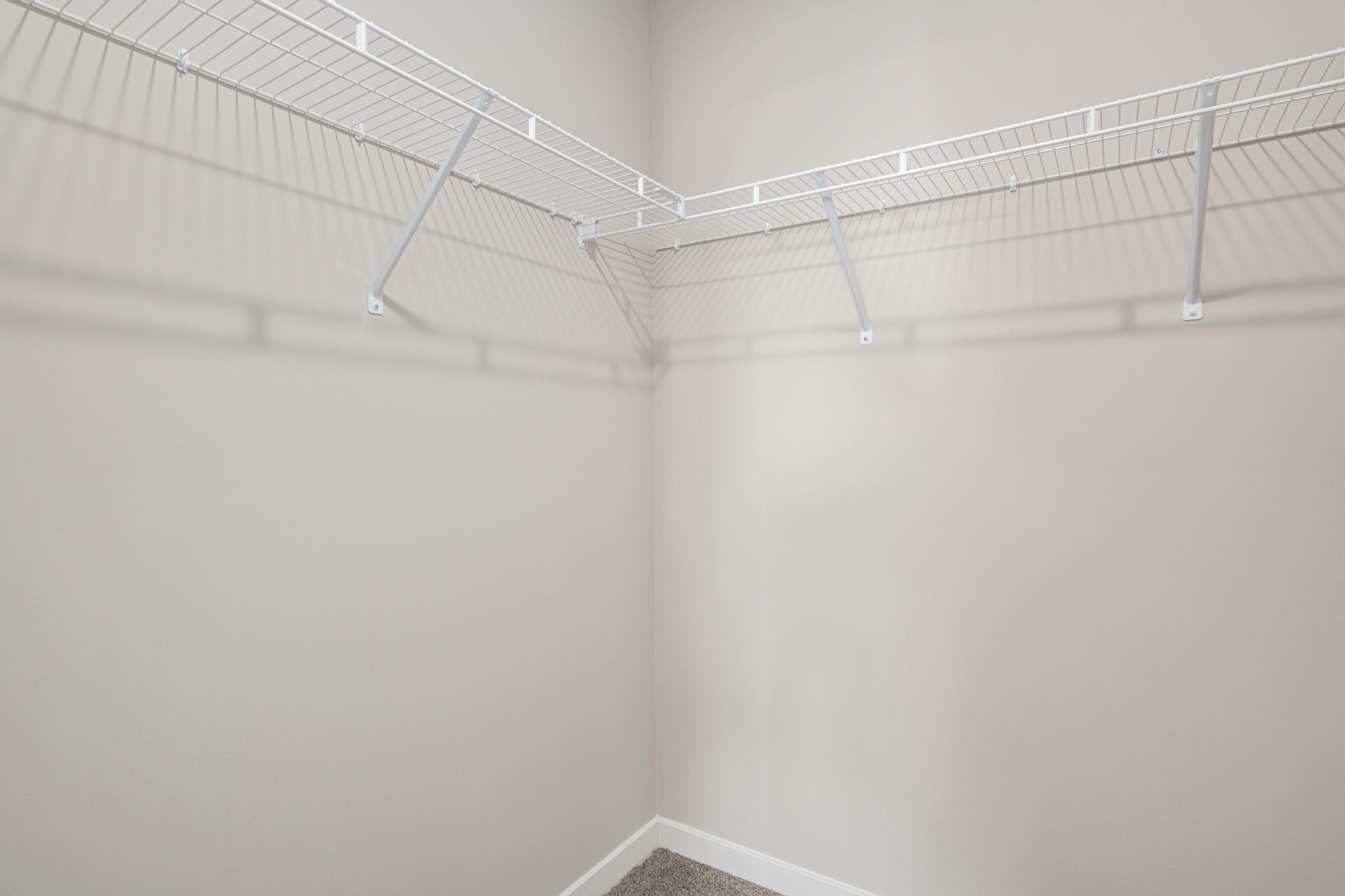 Primary Suite Walk In Closet. Photo taken of another home with similar plan and finishes. Photos and renderings may not depict actual plan, materials, & finishes may vary. All measurements are approximate.