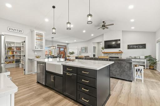 Open concept living will make entertaining a breeze! The center island houses the dishwasher and features a charming farmhouse sink.
