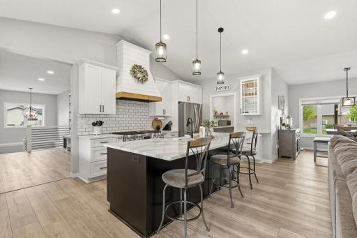 This stunning kitchen exudes elegance with Cambria countertops, stainless steel appliances, a functional center island, and the boss of the home - a Signature kitchen Suite 48 inch Fuel Pro Ranch with 6 Burners and GriddleÂ 