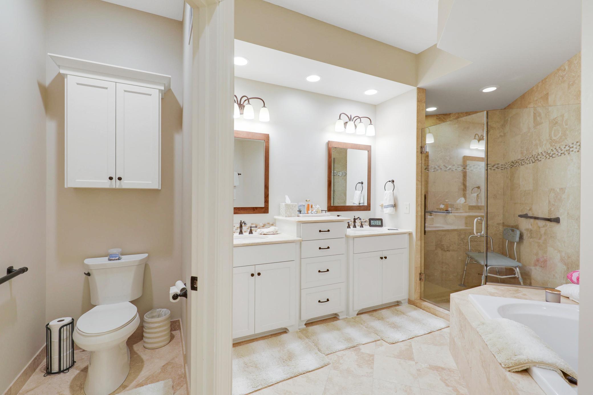 Retreat to a luxurious primary suite featuring serene nature vistas, dual walk-in closets, dual sinks, a soaking tub, a walk-in shower, and a separate water closet.
