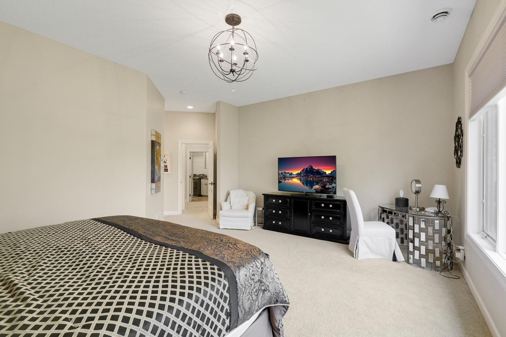 Retreat to a luxurious primary suite featuring serene nature vistas, dual walk-in closets, dual sinks, a soaking tub, a walk-in shower, and a separate water closet.