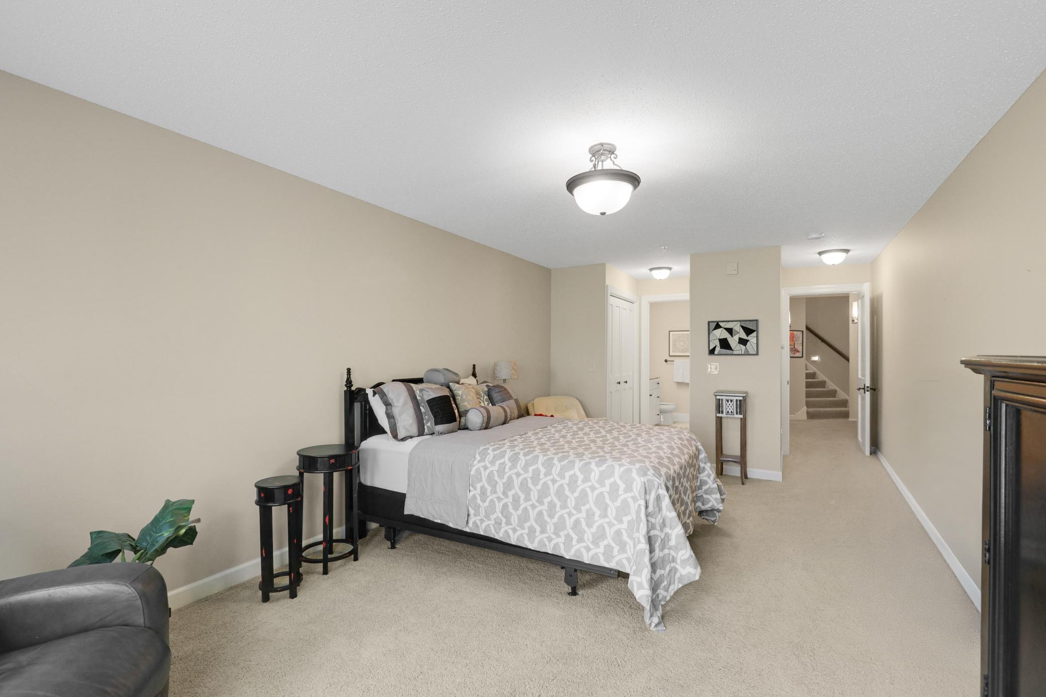 The lower level provides a generously sized third bedroom with a private full bath, dual closets, and direct access to the backyard, plus a utility room and dedicated storage space.