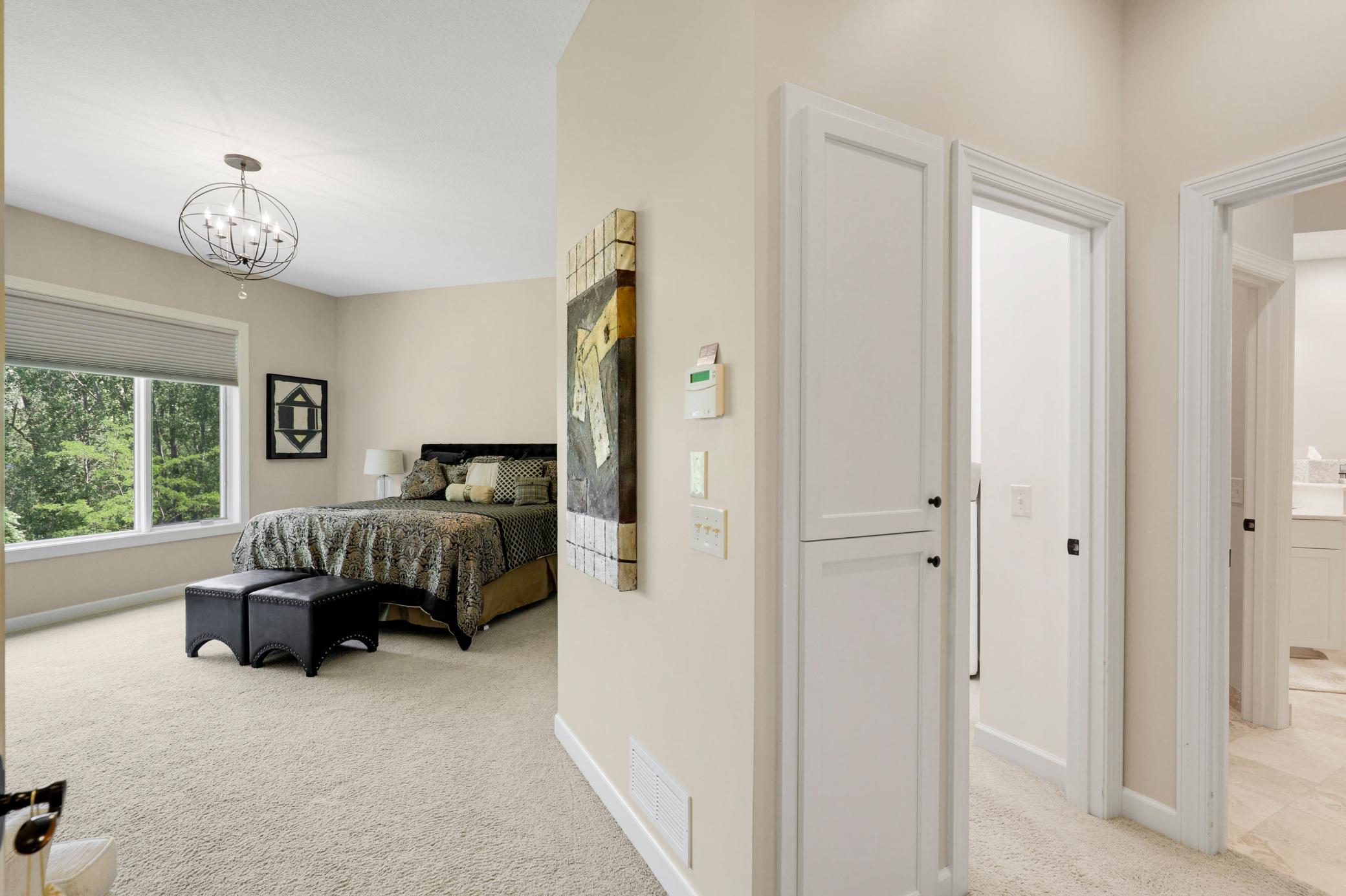 Retreat to a luxurious primary suite featuring serene nature vistas, dual walk-in closets, dual sinks, a soaking tub, a walk-in shower, and a separate water closet.