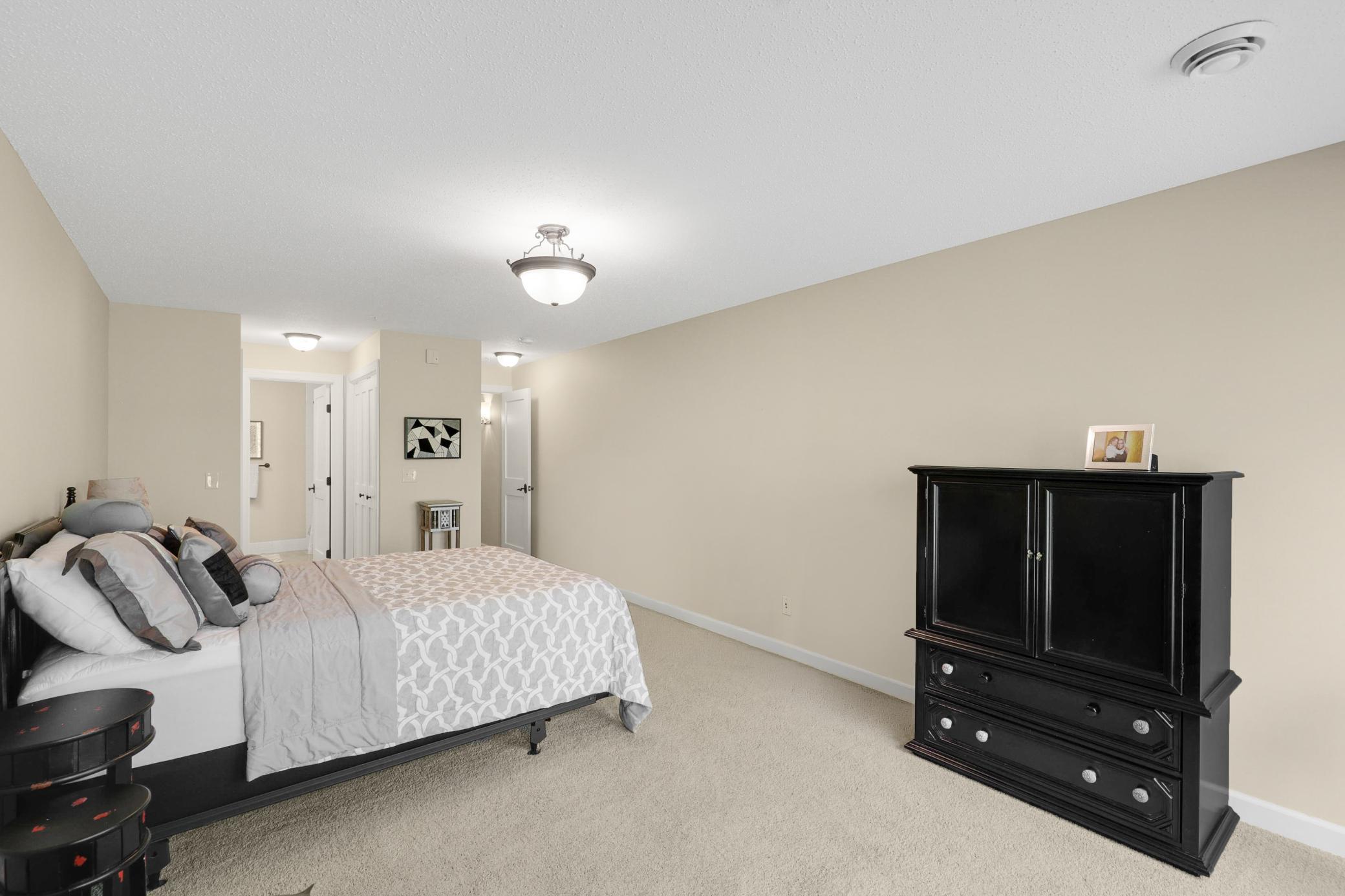 The lower level provides a generously sized third bedroom with a private full bath, dual closets, and direct access to the backyard, plus a utility room and dedicated storage space.