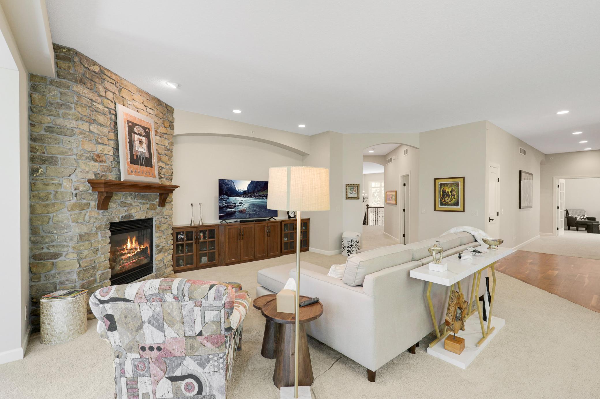 The bright living room is anchored by a gas fireplace with a stone surround and custom built-ins.