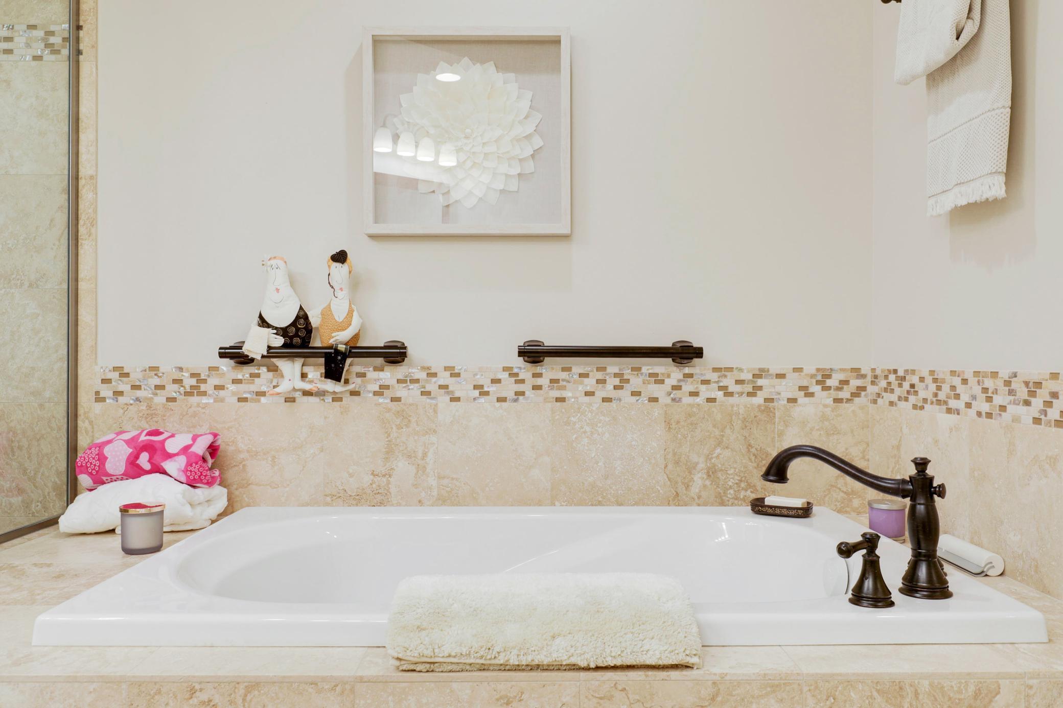 Retreat to a luxurious primary suite featuring serene nature vistas, dual walk-in closets, dual sinks, a soaking tub, a walk-in shower, and a separate water closet.