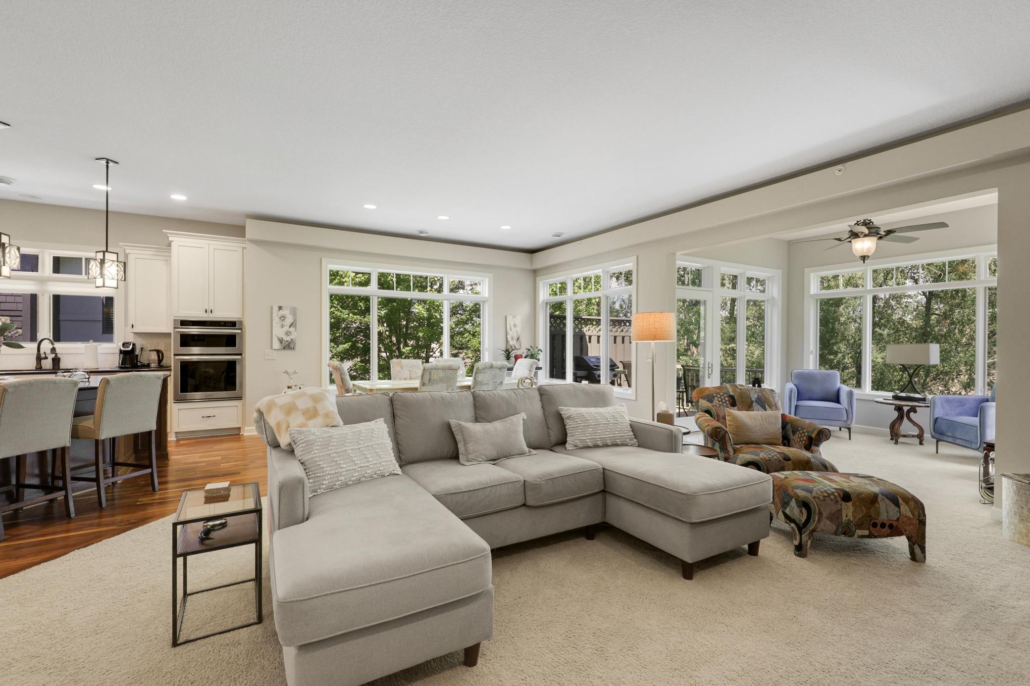 The bright living room is anchored by a gas fireplace with a stone surround and custom built-ins.