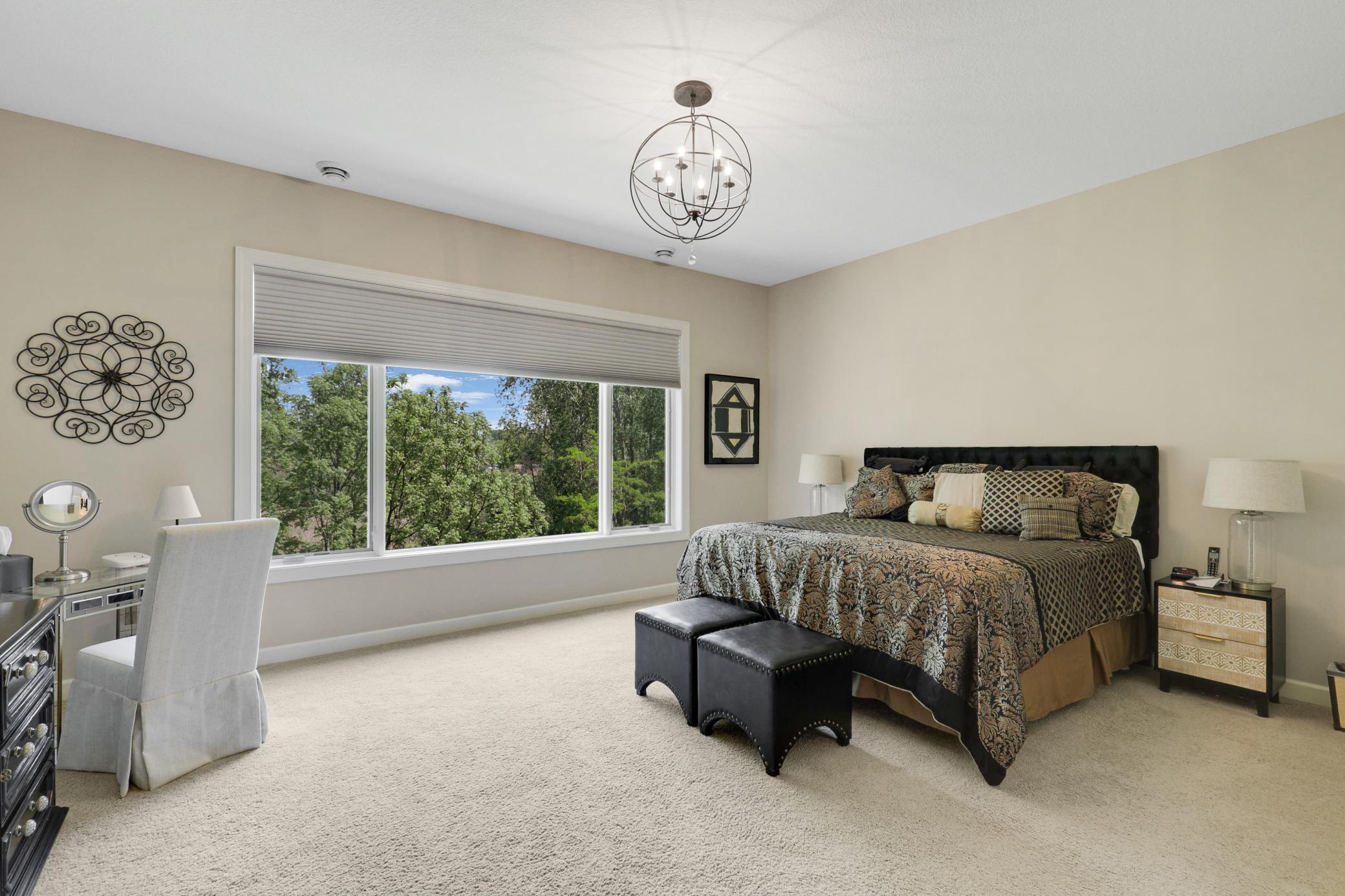 Retreat to a luxurious primary suite featuring serene nature vistas, dual walk-in closets, dual sinks, a soaking tub, a walk-in shower, and a separate water closet.