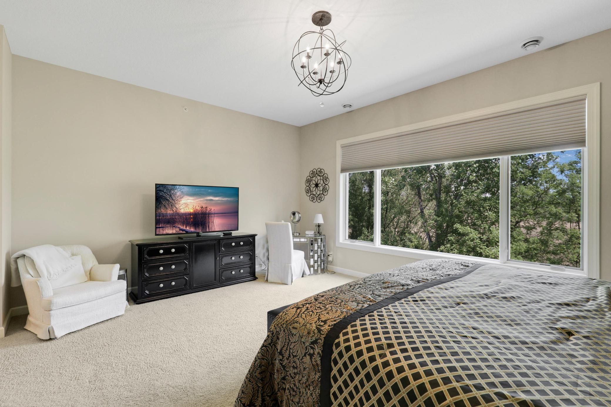 Retreat to a luxurious primary suite featuring serene nature vistas, dual walk-in closets, dual sinks, a soaking tub, a walk-in shower, and a separate water closet.