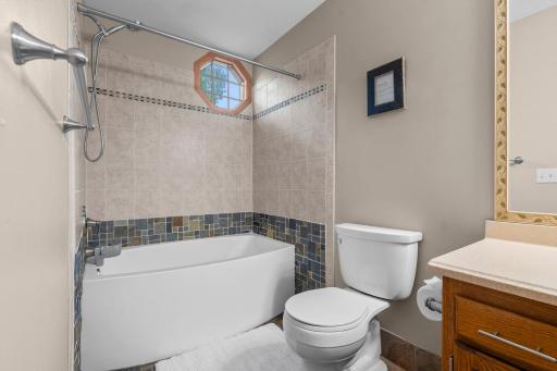 Upper level faull bathroom with large soaking tub and modern tilework.