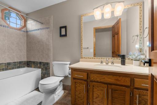 Upper level faull bathroom with large soaking tub and modern tilework.