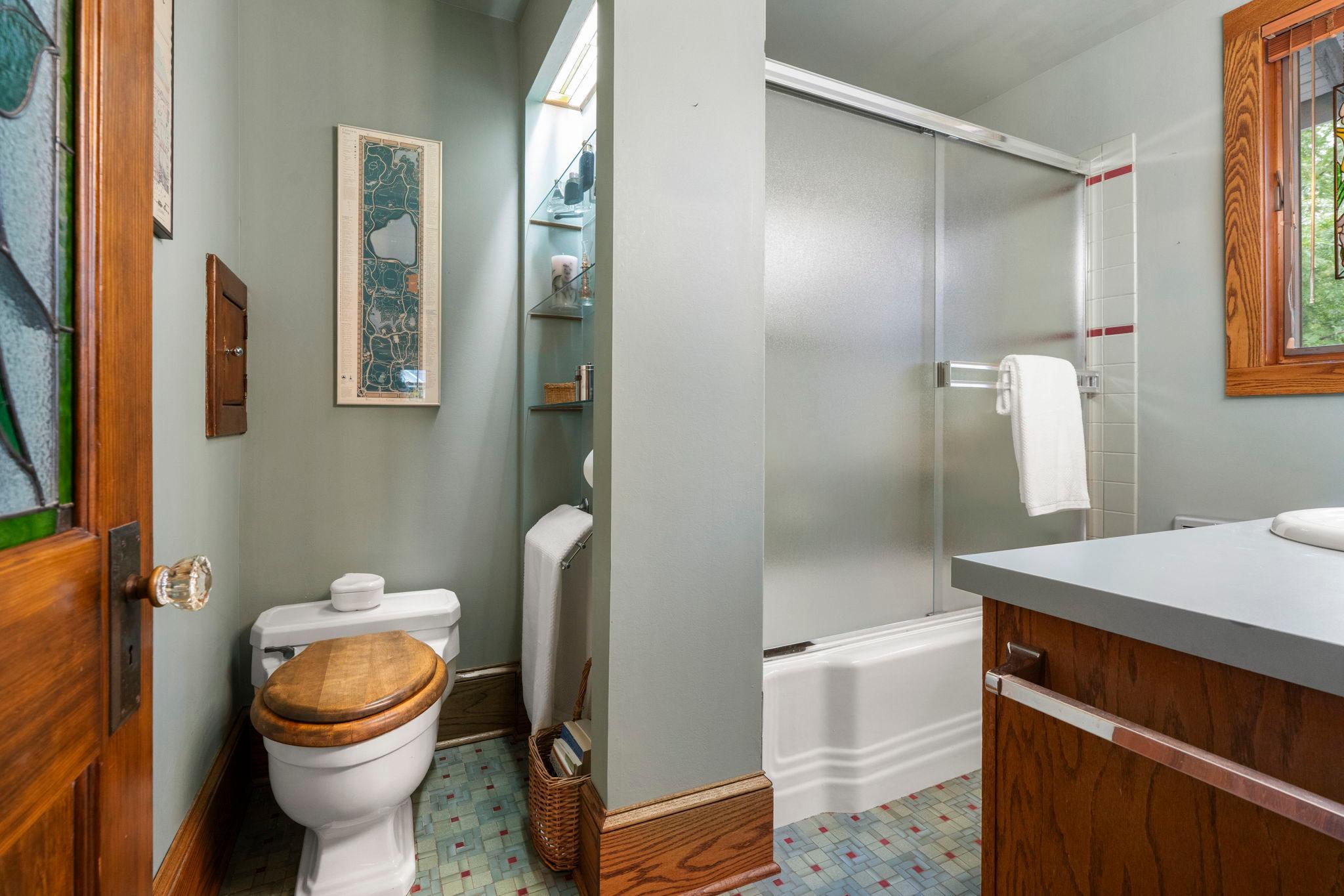 The shower has a ceramic tile surround.