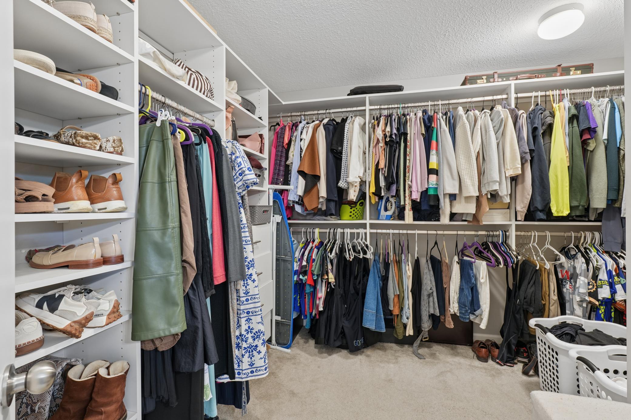 Huge primary bedroom room walk-in closet with elaborate built in shelving.
