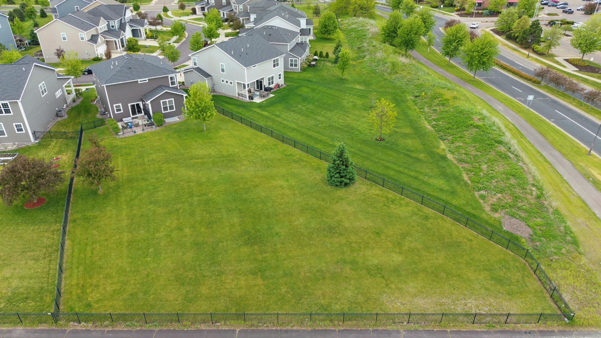 Aerial view of the large fenced in backyard with an in-ground irrigation system.