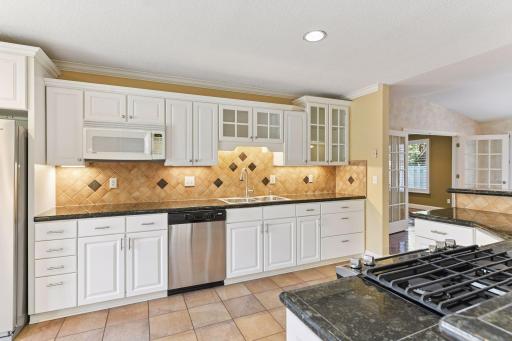 The handsome kitchen with enameled cabinets, ceramic tile back splash, floor and under cabinet lighting.