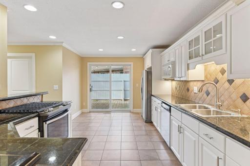 The kitchen runs to an informal dining area and sliding doors to a side patio and garden.