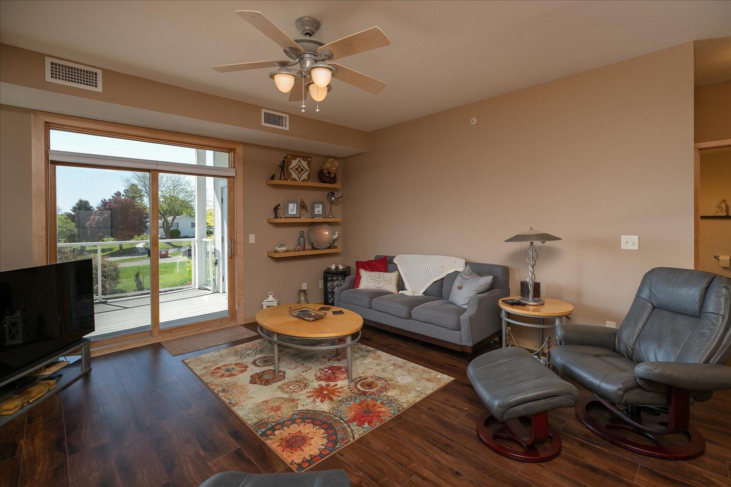 Living Room 18x14 with gas fireplace, new flooring and access to balcony. Open floor plan. Morning sunrises
