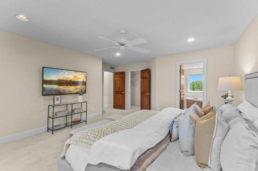 Another view of the primary suite, highlighting the entry to the walk-in closet and the ensuite bathroom.