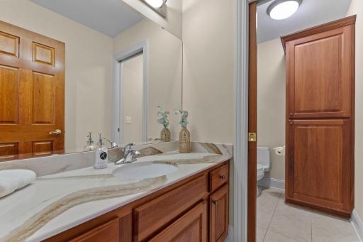 A full upper-level bathroom, conveniently located just steps from all bedrooms, features a stylish vanity updated in 2024 and a pocket door leading to the tub and shower combination with an updated glass shower door.