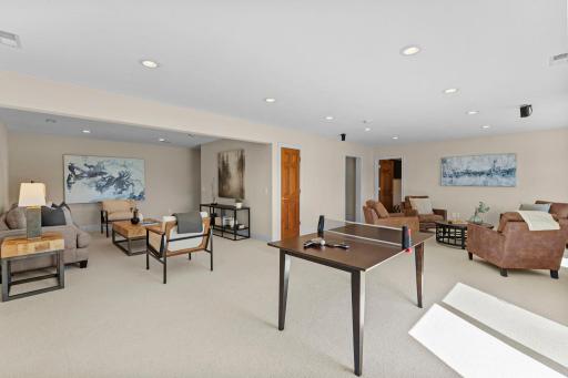 The recreation area offers carpeting, recessed lighting, and direct access to an expansive 38' x 17' concrete patio.