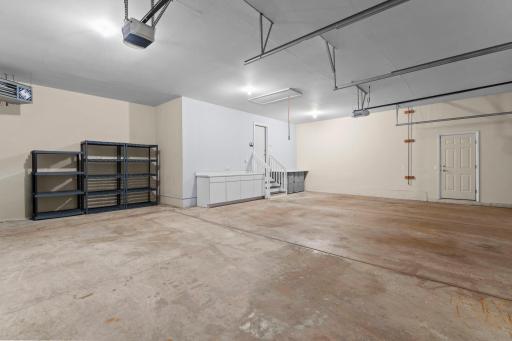The attached three-car garage is heated and insulated, and offers counter space and convenient access to a spacious attic via pull-down ladder for additional storage.
