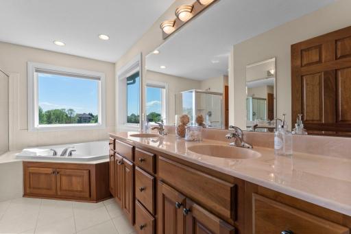The private ensuite offers tile flooring, a dual vanity, a spa-like jetted soaking tub, a walk-in tile shower, and a separate water closet for added privacy.